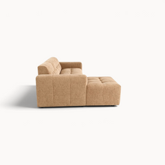 Aika MySofa Nagi loungebank in beige stof met een modern gecapitonneerd ontwerp, zijaanzicht op witte achtergrond.