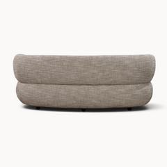 Achterkant van de Aika MySofa Kade 3-zitsbank met een gebogen ontwerp en beige gestructureerde bekleding.