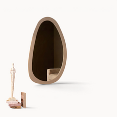 Aika organische spiegel Kumo met een beige frame hangend aan een donkerbruine muur in een stijlvol interieur.