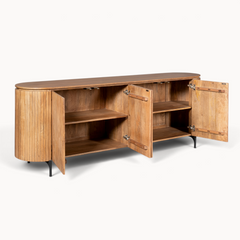 Aika Dressoir Tansu Naturel van lichtbruin hout met afgeronde zijkanten, lamellen deuren en zwarte metalen poten.