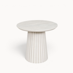 Aika Tansu salontafel in zandkleur met een rond blad en een geribbelde, taps toelopende houten voet.