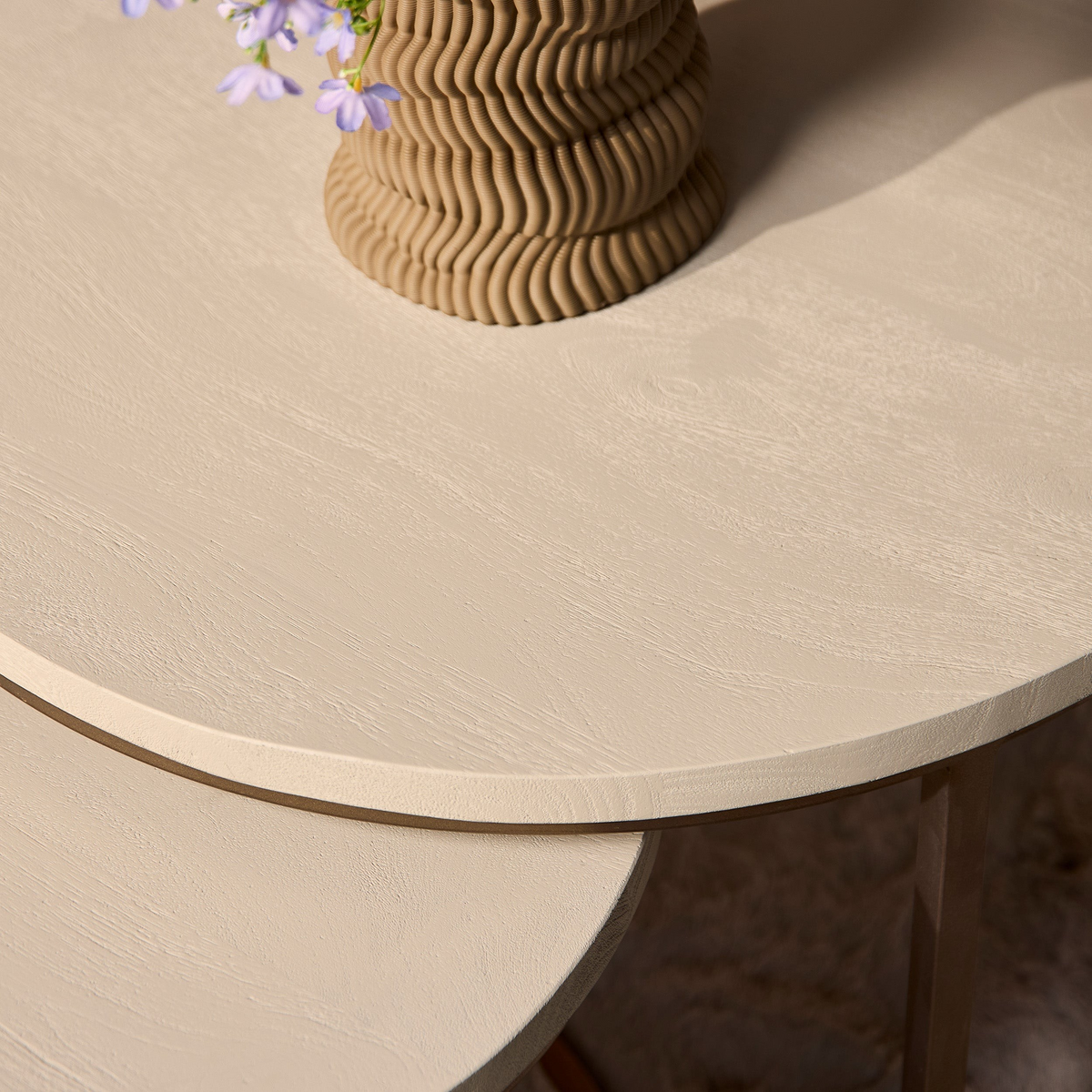 Aika ronde salontafel set Sova in zandkleur met houten textuur en een decoratieve vaas met paarse bloemen