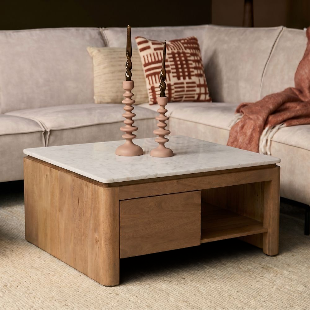 Aika vierkante salontafel Iwa met een naturel houten frame en een wit marmeren blad in een sfeervol interieur.