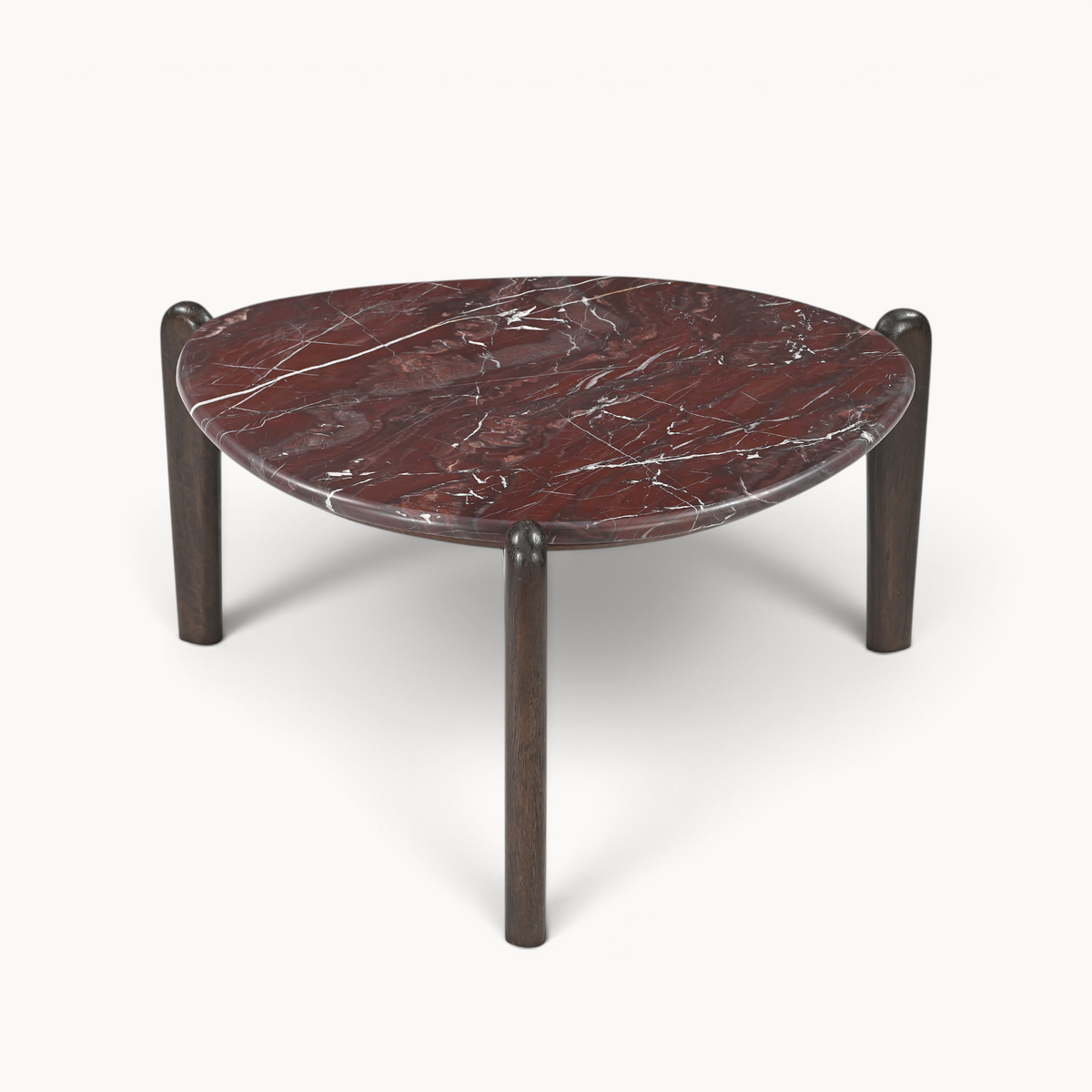 Aika Salontafel Ader met een rond rood marmeren tafelblad en drie donkerhouten poten in een modern design