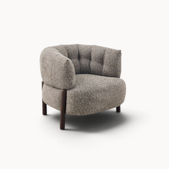 Aika Tsuchi fauteuil met een grijze, getextureerde stoffen bekleding en donkerhouten poten in een modern design.