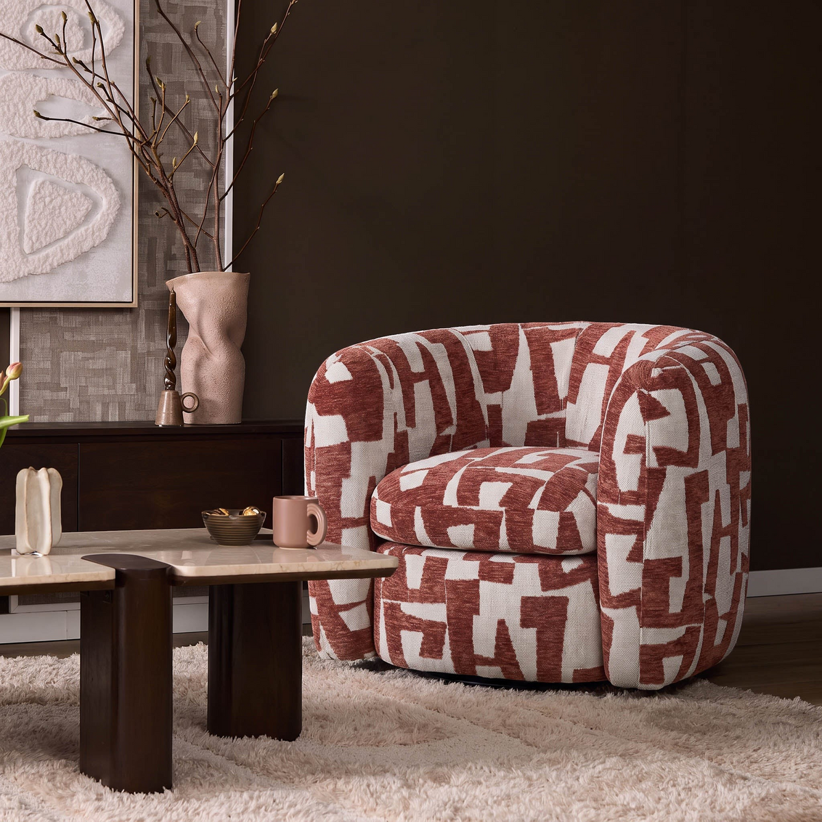 Aika Sakura fauteuil met een rood-wit geometrisch patroon in een stijlvol modern interieur met een beige vloerkleed.