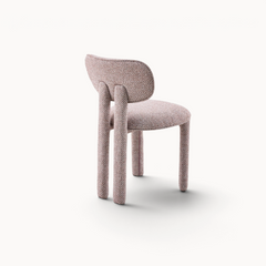 Aika Momo eetkamerstoel in zachtroze bouclé stof met een modern, organisch ontwerp en ronde rugleuning.