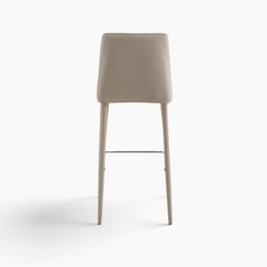 Aika Barkruk Floor in beige met een strak design en slanke poten, gezien vanaf de achterkant.