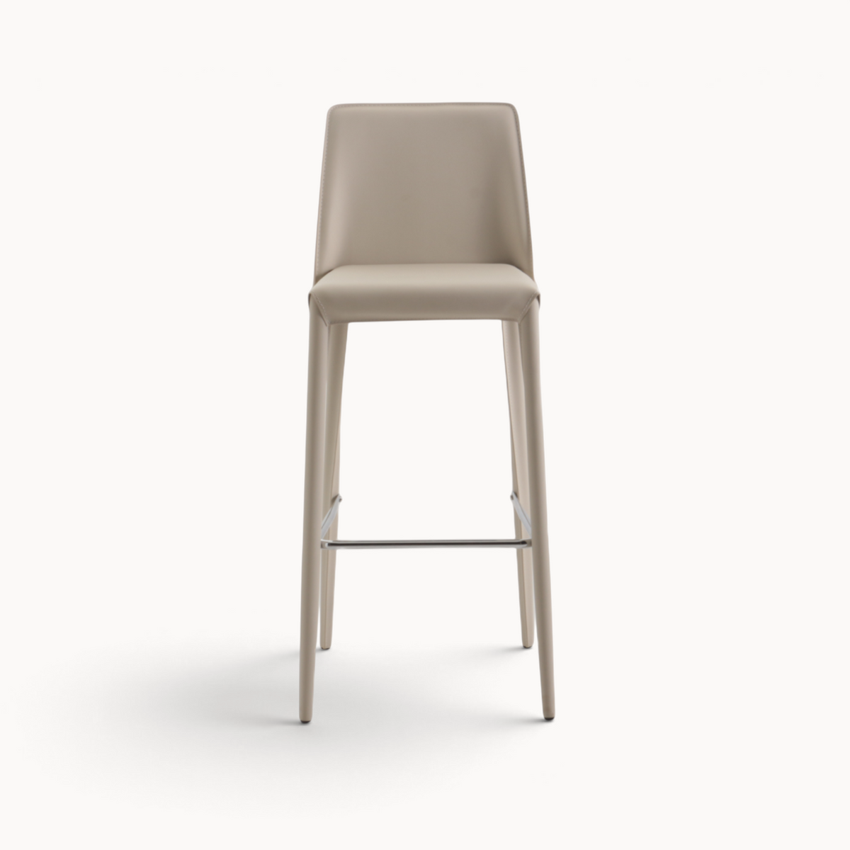 Aika Floor barkruk in beige kunstleer met een slank design en metalen voetensteun, vooraanzicht.