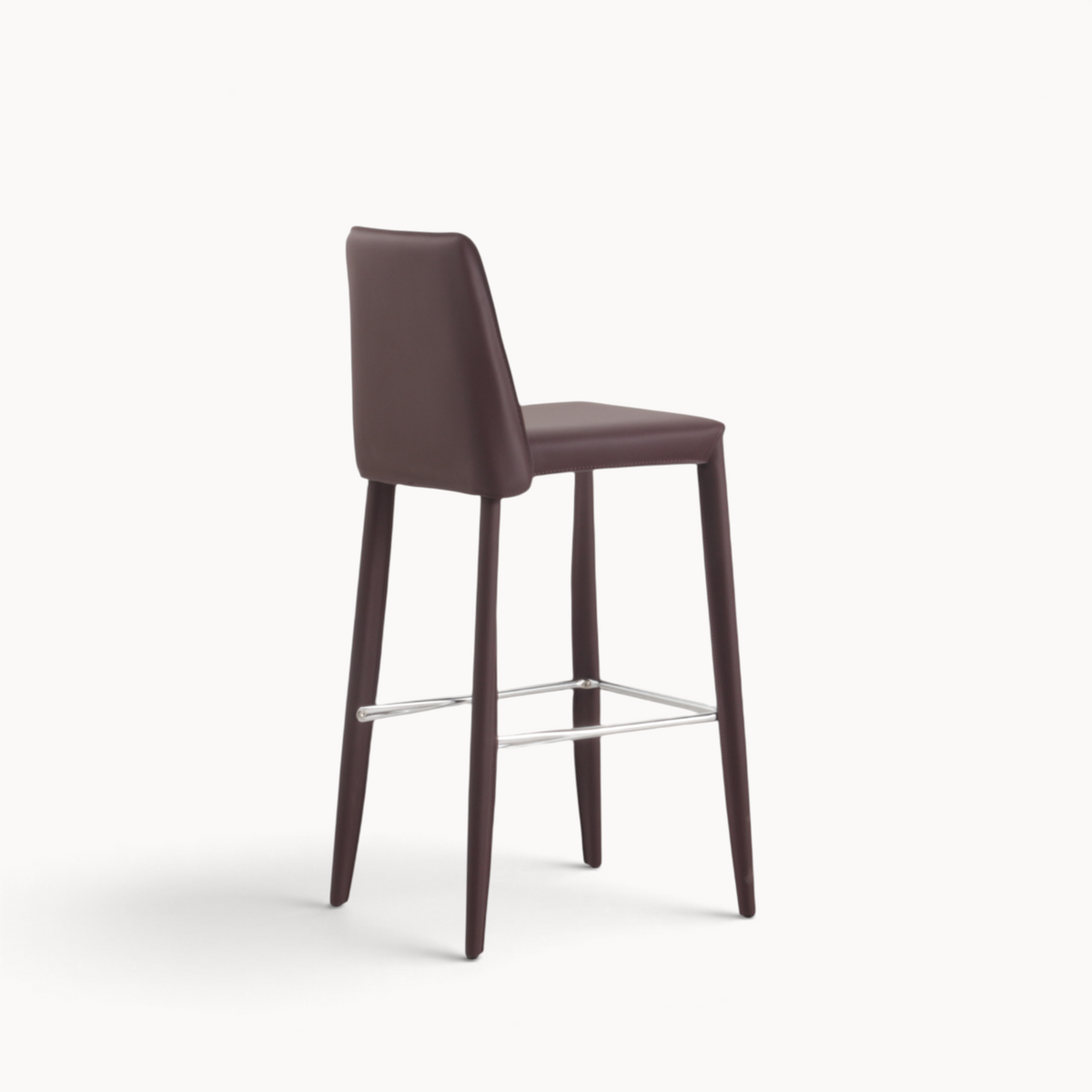 Aika Floor barkruk in donkerbruin kunstleer met een slank design en een zilverkleurige voetensteun