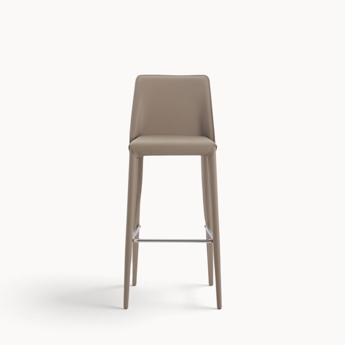 Aika Barkruk Floor in beige met een strak, modern design en een metalen voetensteun op een witte achtergrond.