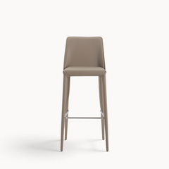 Aika Barkruk Floor in beige met een strak, modern design en een metalen voetensteun op een witte achtergrond.