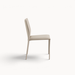 Aika Aki eetkamerstoel in beige kunstleer met een slank en modern design, zijaanzicht.
