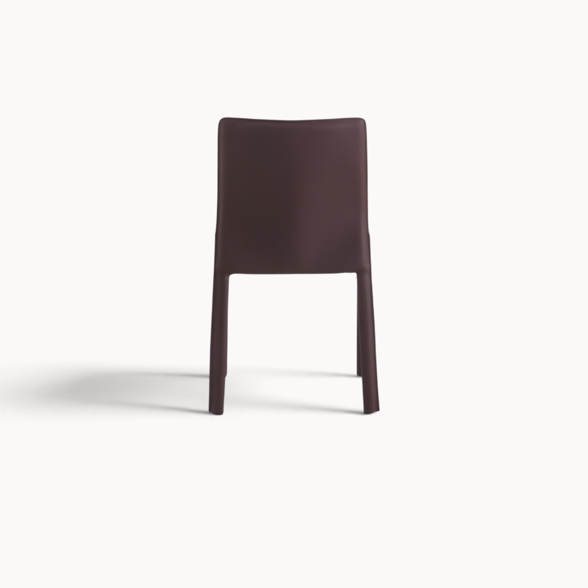 Aika Aki eetkamerstoel in donkerbruin met een minimalistisch en strak design, gezien vanaf de achterkant.