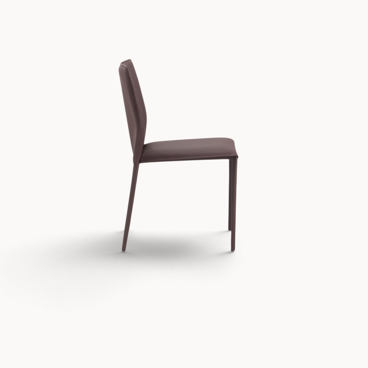 Aika Aki eetkamerstoel in bruin leer met een slank, modern design en strakke lijnen, zijaanzicht.