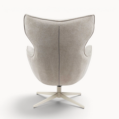 Achterkant van de beige Aika Suzu draaibare fauteuil met een gestoffeerde zitting en een metalen kruispoot.