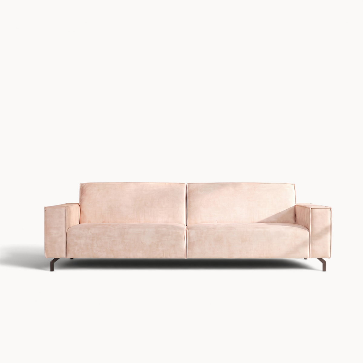 Aika Niwa 2,5-zitsbank bekleed met zacht roze fluweel op slanke zwarte metalen poten in een minimalistisch interieur.