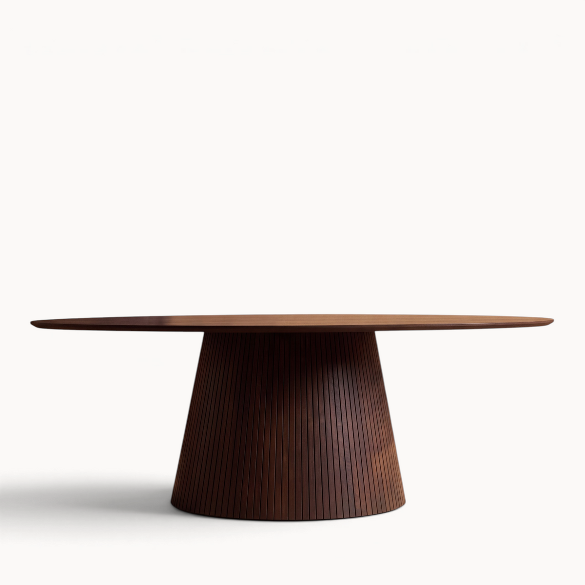 Aika Tansu ovale eettafel in bruin hout met een opvallende conische voet met verticale latten op een lichte achtergrond