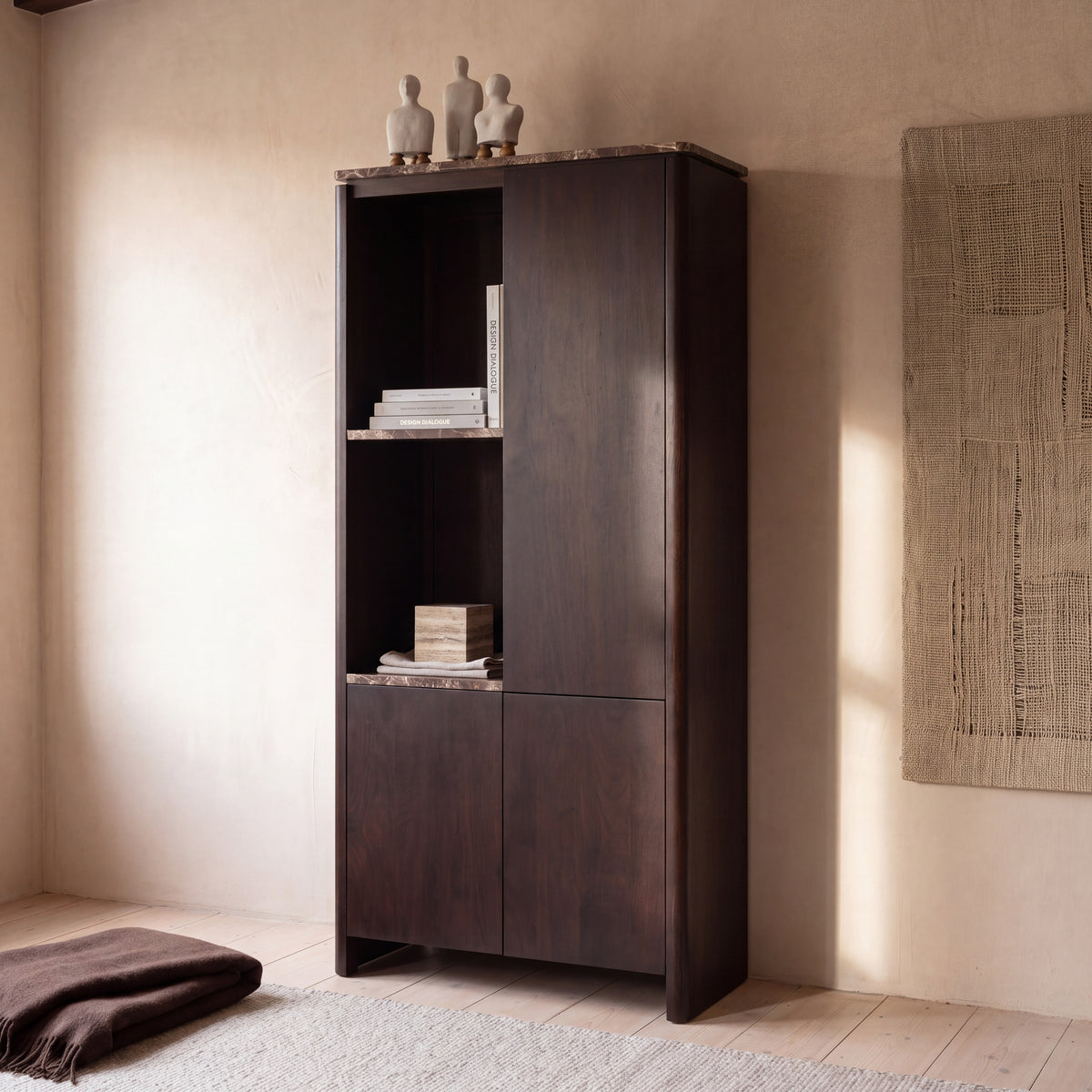 Aika Vakkenkast Iwa Links in bruin hout met bruin marmeren bovenblad en legplanken, gestyled met gipsen objecten en boeken tegen een havermoutkleurige stucwand.